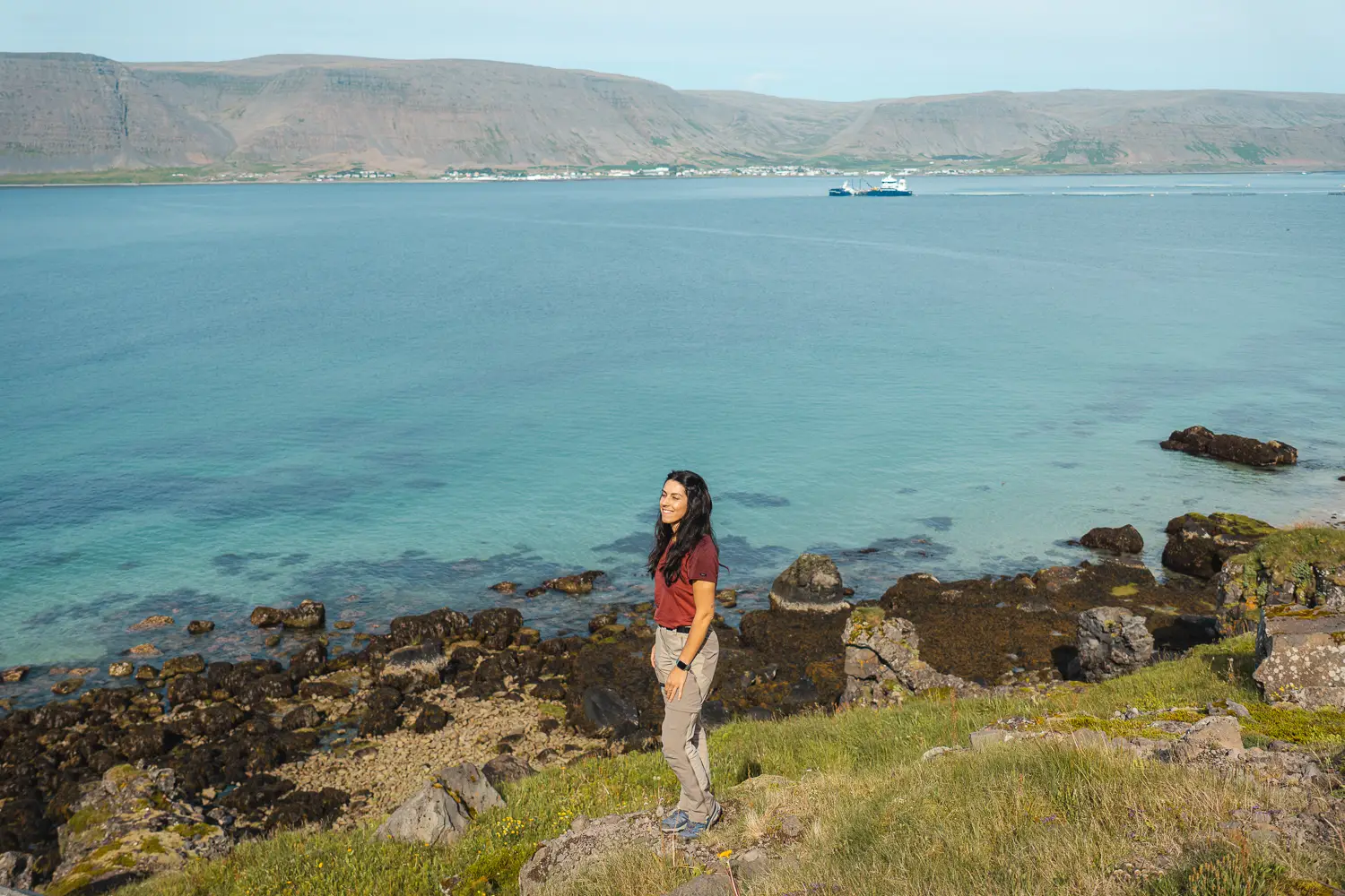 Silvia sonriendo viendo el precioso color turquesa del agua cristalina en uno de los fiordos.