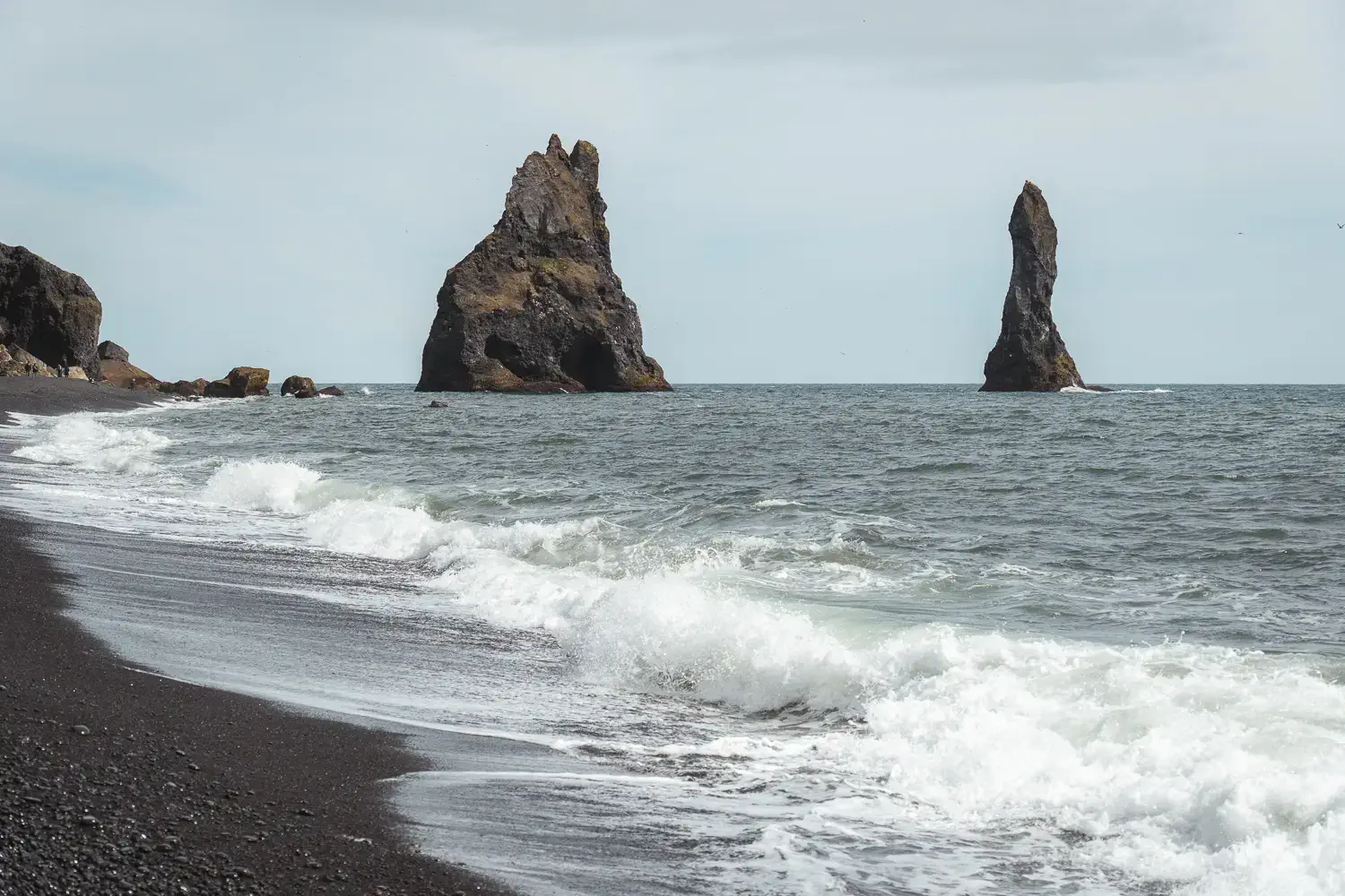 Olas del océano Atlántico rompiendo contra las rocas volcánicas de la playa negra de Reynisfjara, en el sur de Islandia.