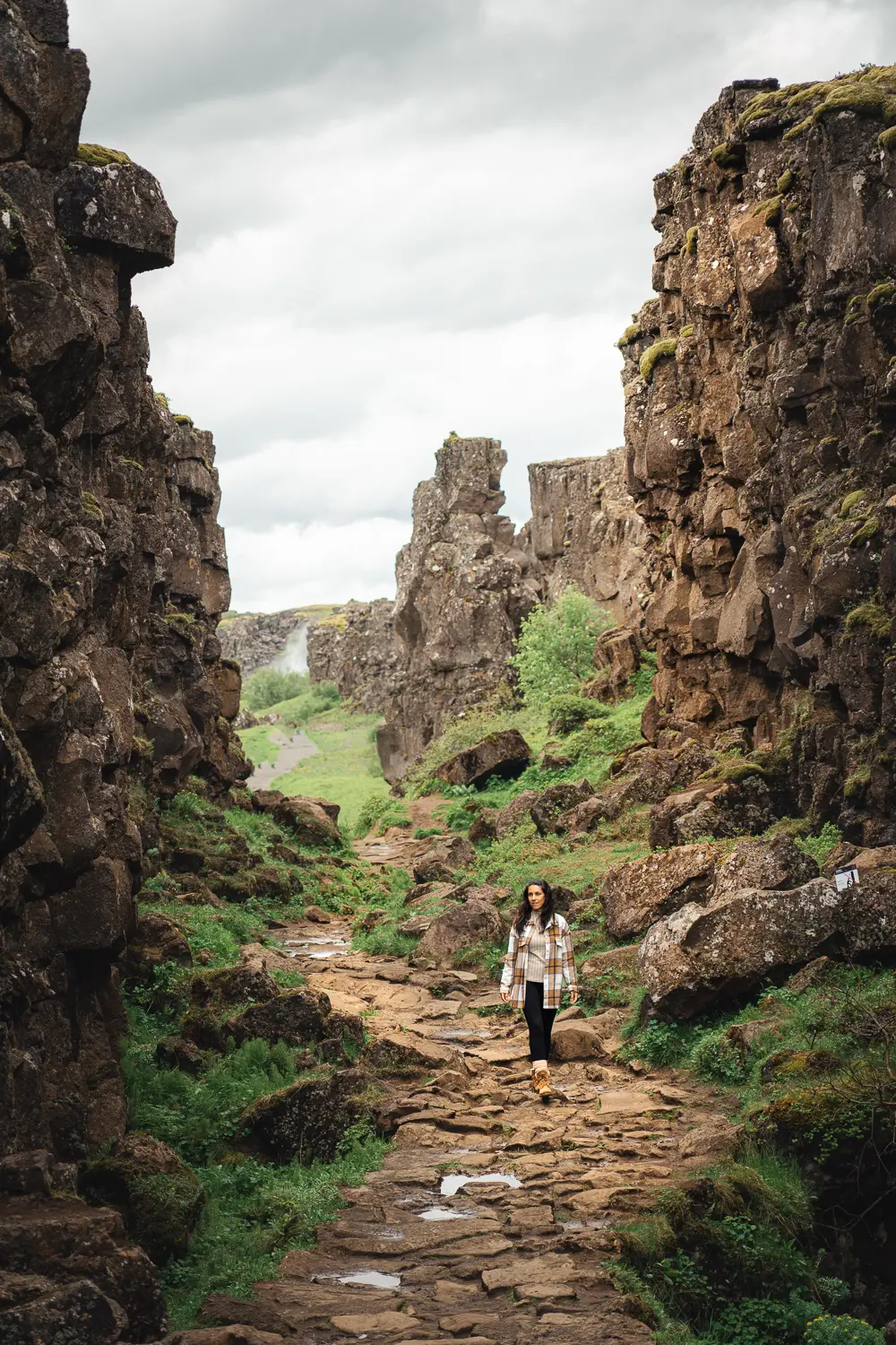 chica entre paredes de piedra formando un pequeño cañón de roca