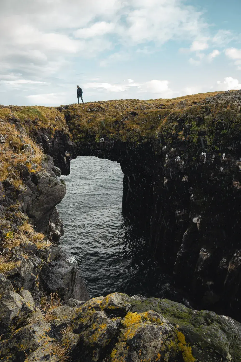 Puente de piedra natural de Arnarstapi sobre el océano Atlántico, en la costa de la península de Snæfellsnes, Islandia.